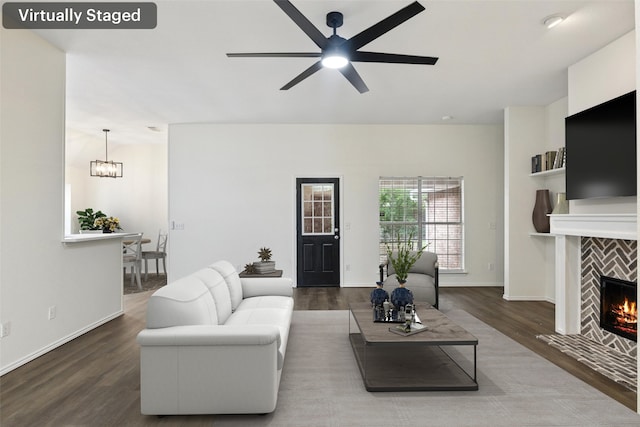 9942 Laurel Ln, Frisco, TX 75035 - living area featuring wood finished floors, ceiling fan, a chandelier, and a tiled fireplace