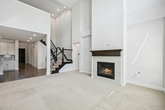 3516 Hathaway Ct, Irving, TX 75062 - unfurnished living room featuring recessed lighting, carpet floors, a towering ceiling, stairway, and a tile fireplace