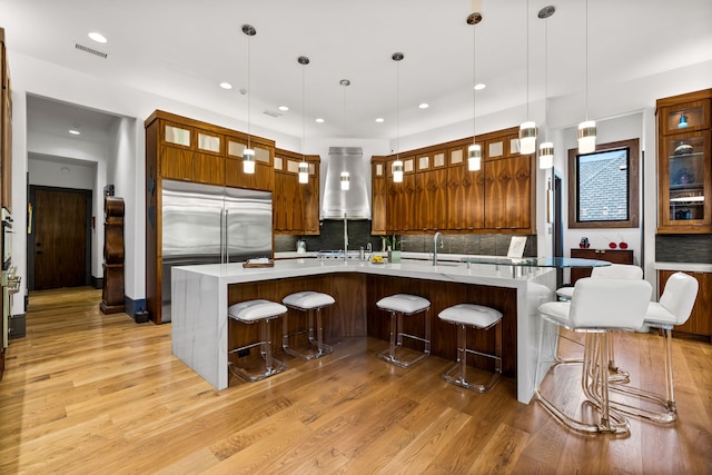 14516 Winnwood Rd, Addison, TX 75254 - kitchen featuring range hood, built in refrigerator, light wood-type flooring, tasteful backsplash, and recessed lighting