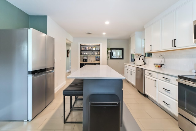 4912 Odessa Ave, Fort Worth, TX 76133 - kitchen featuring stainless steel appliances, a kitchen island, white cabinets, tasteful backsplash, and light countertops
