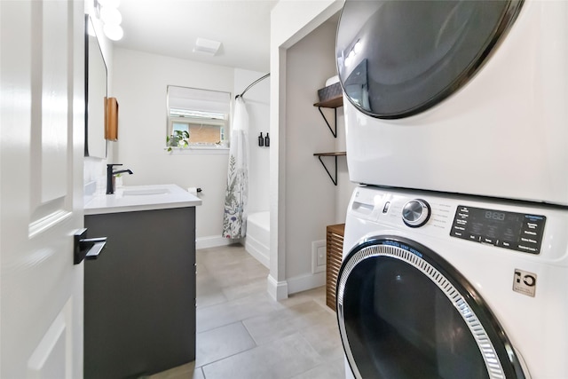4912 Odessa Ave, Fort Worth, TX 76133 - laundry area with stacked washer / drying machine and light tile patterned floors