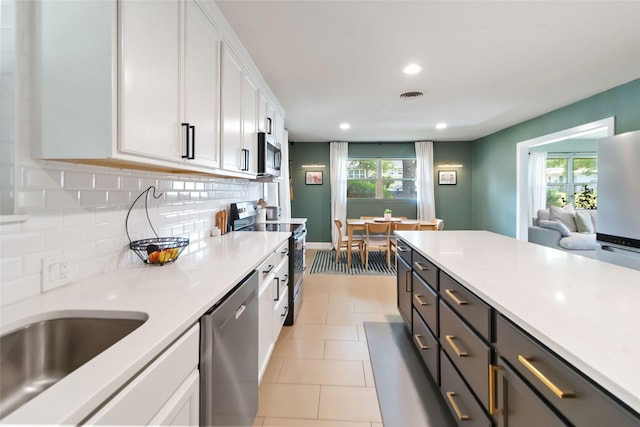 4912 Odessa Ave, Fort Worth, TX 76133 - kitchen featuring stainless steel appliances, white cabinets, light countertops, recessed lighting, and backsplash