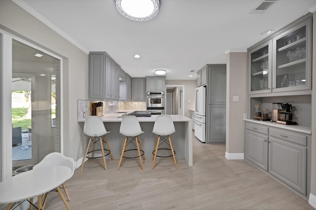 6375 Lansdale Rd, Fort Worth, TX 76116 - kitchen with gray cabinetry, freestanding refrigerator, a peninsula, double oven, and glass insert cabinets