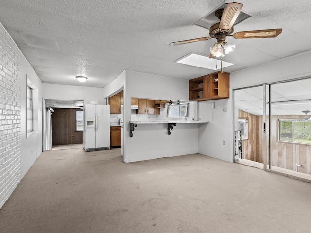 415 S Union St, Montague, TX 76251 - unfurnished living room featuring a ceiling fan, a textured ceiling, light colored carpet, and wood walls