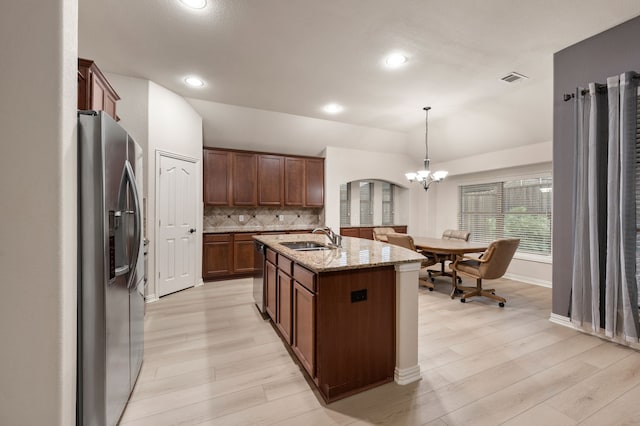 8225 Courtney Way, Watauga, TX 76148 - kitchen with appliances with stainless steel finishes, lofted ceiling, light wood-style flooring, light stone counters, and backsplash