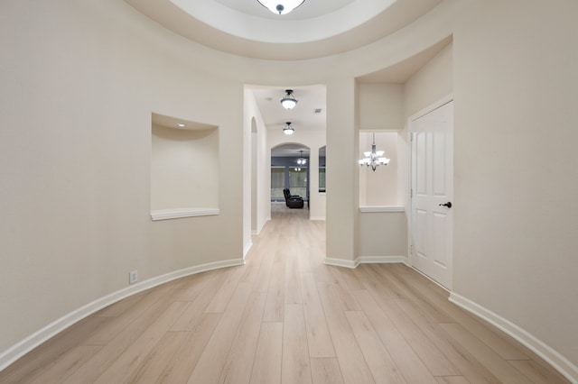 8225 Courtney Way, Watauga, TX 76148 - corridor featuring arched walkways, a chandelier, and light wood-style floors