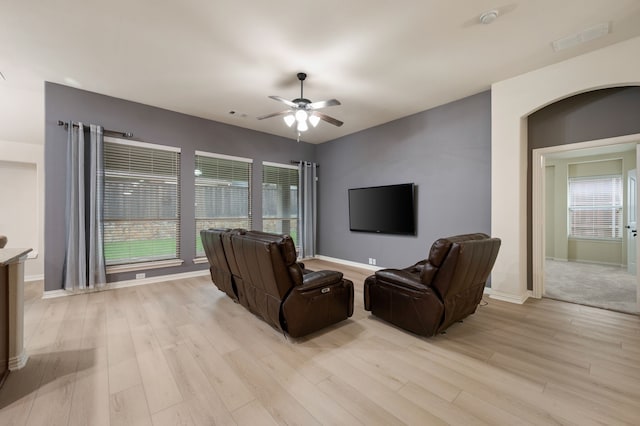 8225 Courtney Way, Watauga, TX 76148 - living room with light wood-style flooring, a ceiling fan, and arched walkways