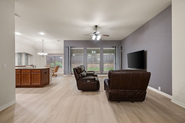 8225 Courtney Way, Watauga, TX 76148 - living room featuring a chandelier, light wood-style floors, and a ceiling fan