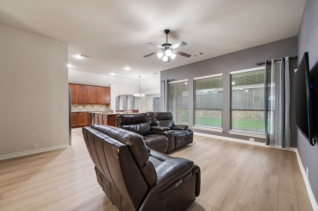 8225 Courtney Way, Watauga, TX 76148 - living room with ceiling fan, light wood-style floors, and a chandelier