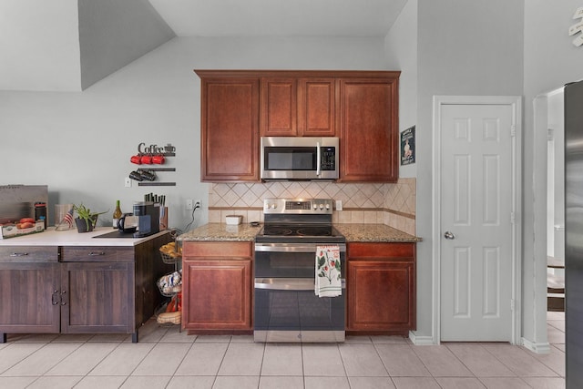 905 Austin Acre, Sulphur Springs, TX 75482 - kitchen with stainless steel appliances, decorative backsplash, light tile patterned flooring, lofted ceiling, and light stone counters
