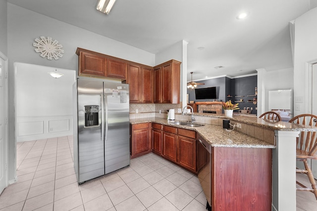 905 Austin Acre, Sulphur Springs, TX 75482 - kitchen featuring stainless steel appliances, a peninsula, light tile patterned floors, ceiling fan, and a wainscoted wall