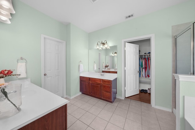 905 Austin Acre, Sulphur Springs, TX 75482 - full bath featuring two vanities, a shower stall, tile patterned floors, a walk in closet, and a chandelier