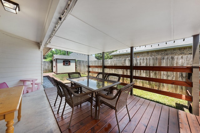 905 Austin Acre, Sulphur Springs, TX 75482 - wooden terrace with outdoor dining space, a storage unit, and a fenced backyard