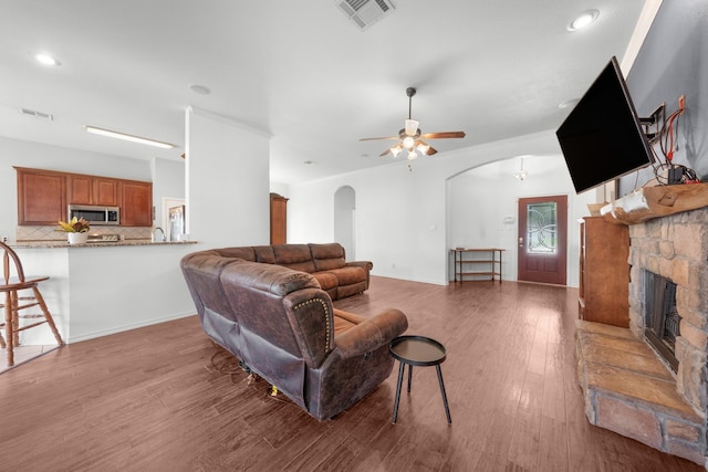 905 Austin Acre, Sulphur Springs, TX 75482 - living room featuring arched walkways, a fireplace, wood finished floors, a ceiling fan, and recessed lighting