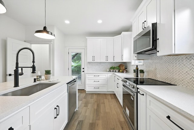826 W Canty St, Dallas, TX 75208 - kitchen featuring stainless steel appliances, light wood-style floors, white cabinetry, and recessed lighting