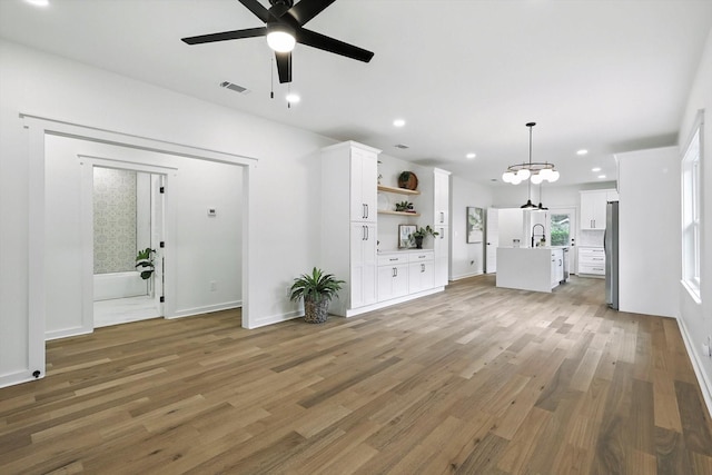 826 W Canty St, Dallas, TX 75208 - unfurnished living room featuring a ceiling fan, light wood-style flooring, a chandelier, and recessed lighting
