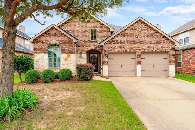 209 Willet Ct, Little Elm, TX 75068 - traditional-style house with brick siding, a garage, concrete driveway, stone siding, and a front yard
