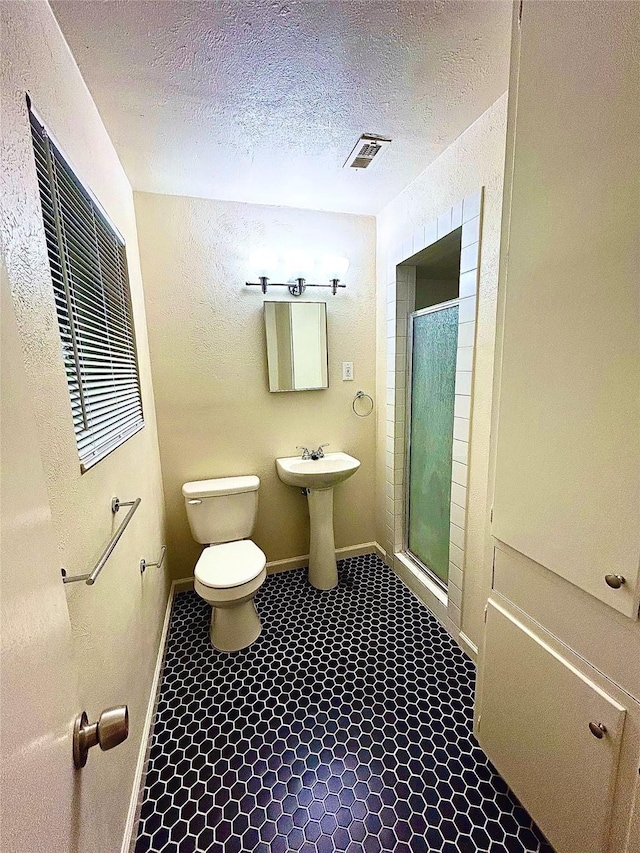 128 Robert St, Burleson, TX 76028 - bathroom featuring a shower stall, a textured ceiling, and tile patterned floors