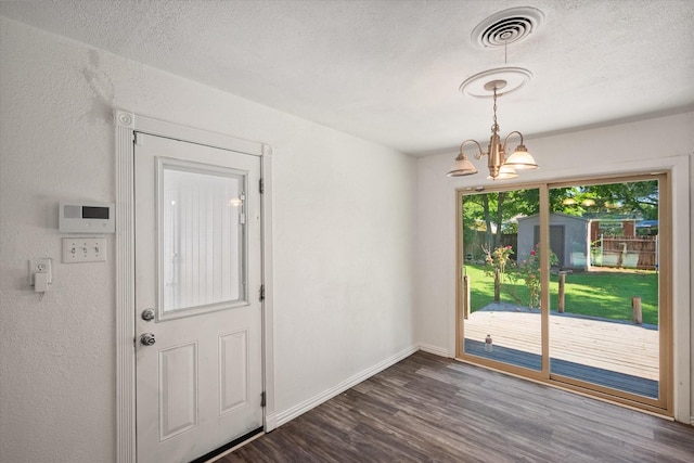 612 Elm St, Hurst, TX 76053 - unfurnished dining area featuring dark wood-style flooring, a chandelier, and a textured ceiling