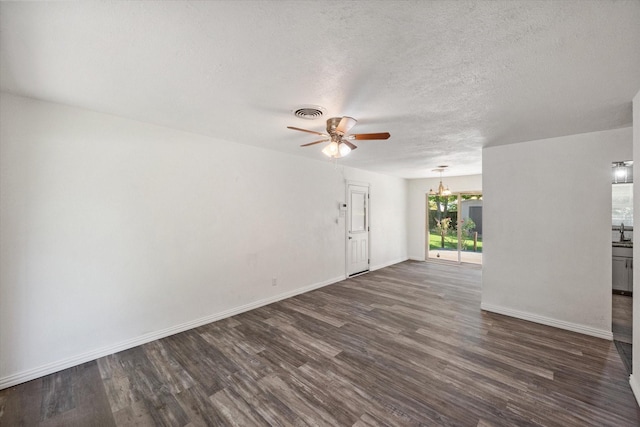 612 Elm St, Hurst, TX 76053 - unfurnished living room featuring a ceiling fan, dark wood-style floors, a textured ceiling, and a chandelier