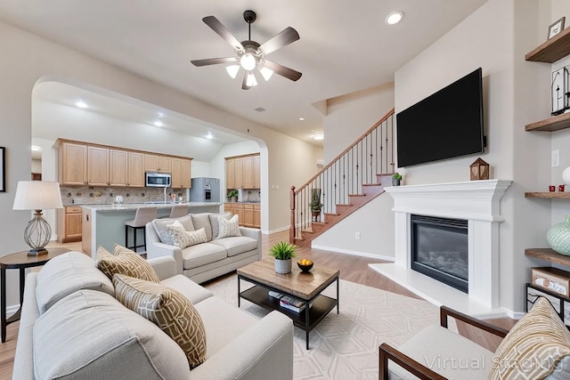 505 Glacier St, Desoto, TX 75115 - living area featuring light wood-type flooring, a ceiling fan, recessed lighting, a glass covered fireplace, and stairs