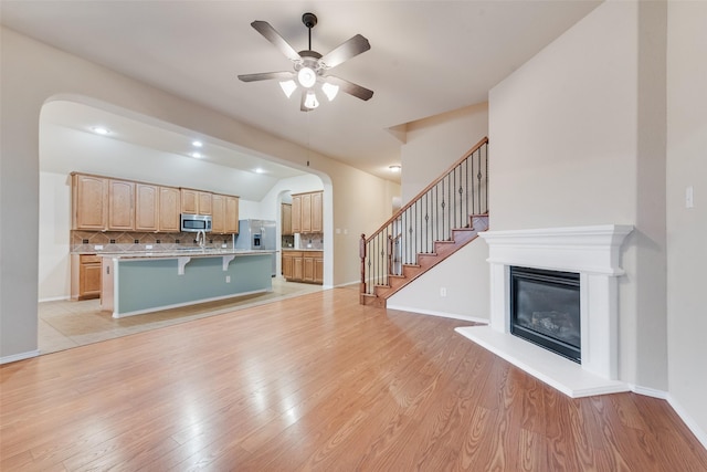 505 Glacier St, Desoto, TX 75115 - unfurnished living room featuring a ceiling fan, stairway, light wood-style flooring, a glass covered fireplace, and lofted ceiling