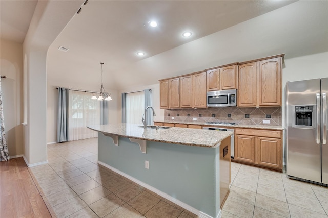 505 Glacier St, Desoto, TX 75115 - kitchen with appliances with stainless steel finishes, tasteful backsplash, a chandelier, light stone counters, and a center island with sink