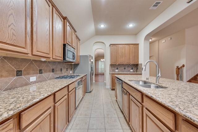 505 Glacier St, Desoto, TX 75115 - kitchen with stainless steel appliances, arched walkways, light stone countertops, light tile patterned floors, and lofted ceiling