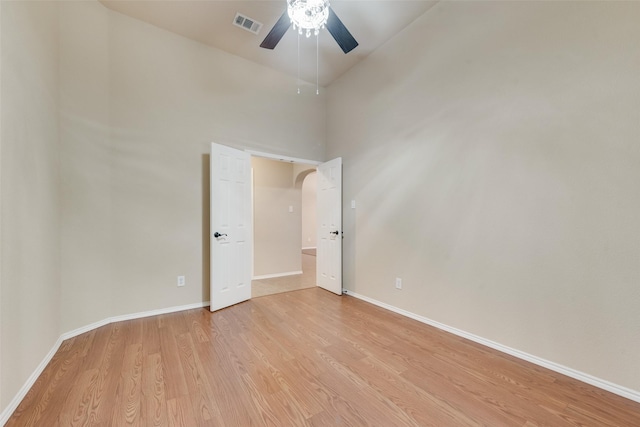 505 Glacier St, Desoto, TX 75115 - empty room featuring light wood finished floors, ceiling fan, arched walkways, and a high ceiling