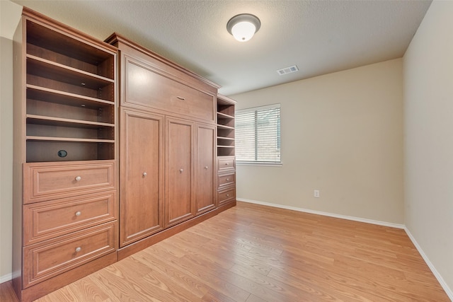 505 Glacier St, Desoto, TX 75115 - unfurnished bedroom featuring light wood-style flooring and a textured ceiling