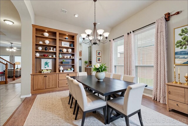 505 Glacier St, Desoto, TX 75115 - dining area featuring a chandelier, light wood-style floors, ceiling fan, and arched walkways