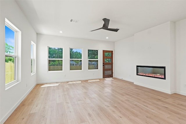420 N Moore St, Dallas, TX 75203 - unfurnished living room featuring light wood-style flooring, a glass covered fireplace, ceiling fan, and recessed lighting