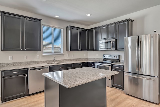 529 Mesa View Trl, Fort Worth, TX 76131 - kitchen featuring appliances with stainless steel finishes, light wood finished floors, a center island, recessed lighting, and light stone countertops