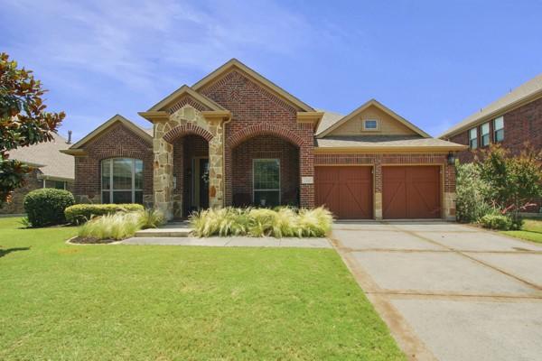 1165 Breakwater Dr, Frisco, TX 75036 - view of front facade with brick siding, a garage, a front yard, and driveway