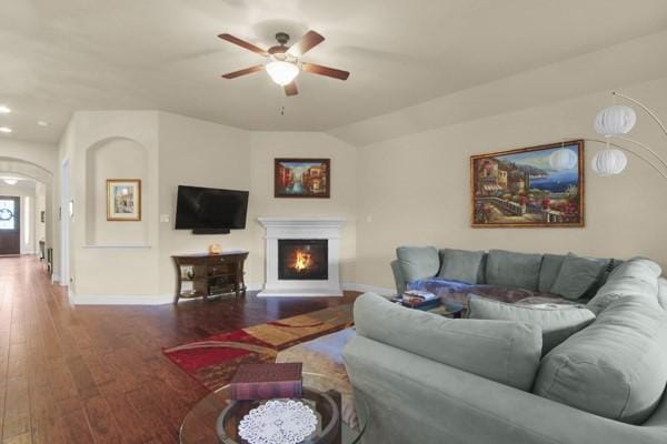 1165 Breakwater Dr, Frisco, TX 75036 - living area featuring a ceiling fan, wood finished floors, a lit fireplace, recessed lighting, and arched walkways