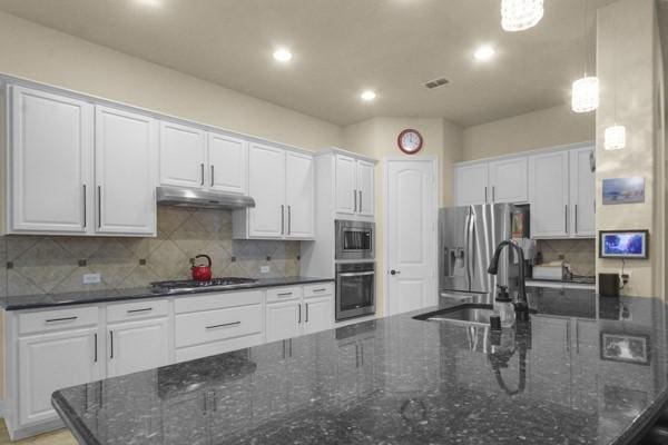 1165 Breakwater Dr, Frisco, TX 75036 - kitchen with stainless steel appliances, under cabinet range hood, white cabinetry, backsplash, and recessed lighting