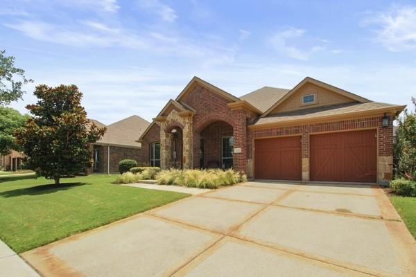 1165 Breakwater Dr, Frisco, TX 75036 - view of front of home featuring brick siding, a garage, a front lawn, and driveway