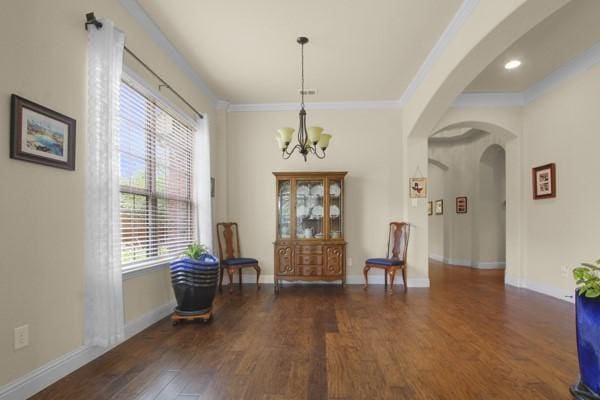 1165 Breakwater Dr, Frisco, TX 75036 - living area featuring arched walkways, wood finished floors, ornamental molding, and a chandelier