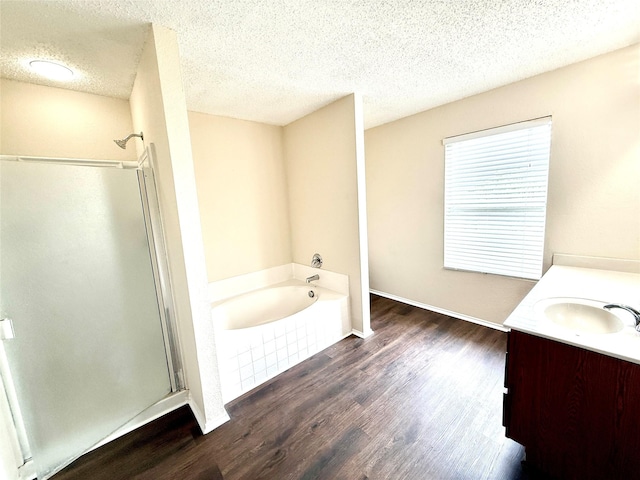 2024 Kings Forest Dr, Heartland, TX 75126 - bathroom with a stall shower, vanity, a garden tub, wood finished floors, and a textured ceiling