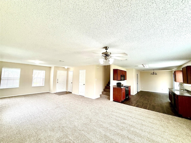 2024 Kings Forest Dr, Heartland, TX 75126 - unfurnished living room featuring dark colored carpet, ceiling fan, stairway, and a textured ceiling