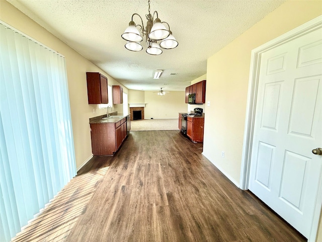 2024 Kings Forest Dr, Heartland, TX 75126 - kitchen featuring black appliances, open floor plan, a chandelier, dark wood-type flooring, and a textured ceiling