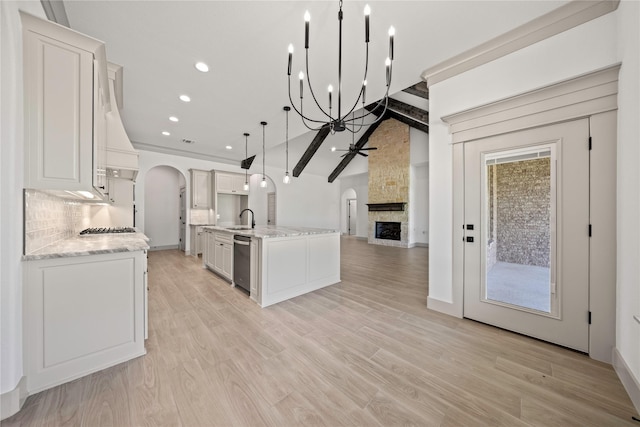 716 Burr Oak Ln, Weatherford, TX 76085 - kitchen with ceiling fan, arched walkways, open floor plan, a stone fireplace, and appliances with stainless steel finishes