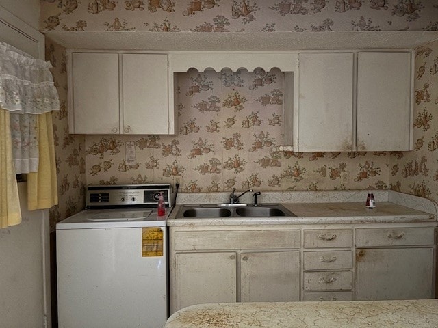 4317 Gram Ln, Waco, TX 76705 - kitchen with washer / clothes dryer, wallpapered walls, and light countertops