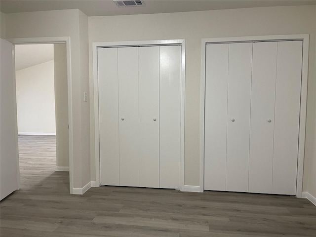 2113 Glencrest Ln, Garland, TX 75040 - unfurnished bedroom featuring multiple closets and wood finished floors