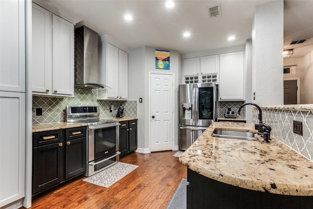 1504 Vista Bend Dr, Allen, TX 75002 - kitchen with appliances with stainless steel finishes, wall chimney exhaust hood, dark wood-type flooring, tasteful backsplash, and light stone counters