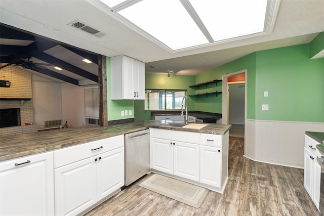 10202 Fm 1895, Kaufman, TX 75142 - kitchen with dishwasher, a peninsula, a wainscoted wall, white cabinetry, and open floor plan