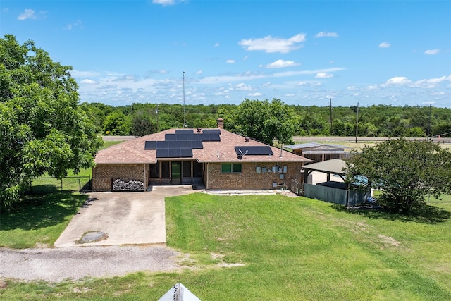 10202 Fm 1895, Kaufman, TX 75142 - view of front of home with roof mounted solar panels, brick siding, roof with shingles, concrete driveway, and a chimney