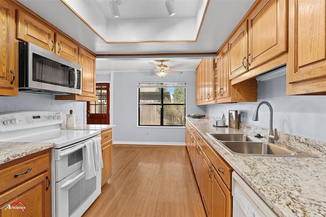 10030 Alondra St, Shreveport, LA 71115 - kitchen with white appliances, a raised ceiling, light wood finished floors, a ceiling fan, and brown cabinetry
