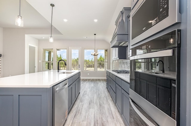 7050 Champion Rd, Midlothian, TX 76065 - kitchen featuring stainless steel appliances, light wood-type flooring, gray cabinets, pendant lighting, and custom exhaust hood