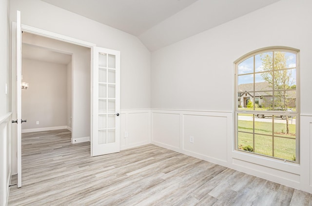 7050 Champion Rd, Midlothian, TX 76065 - empty room with french doors, light wood finished floors, lofted ceiling, a wainscoted wall, and a chandelier